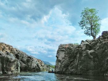 Scenic view of sea by cliff against sky