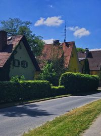 Road by buildings against sky in city