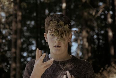 Portrait of young man throwing leaves