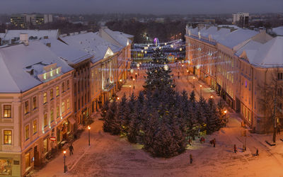 Illuminated town against sky at night