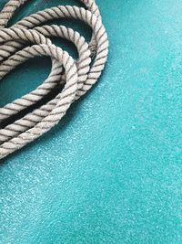 High angle view of rope on blue footpath
