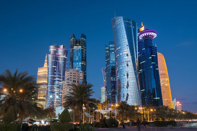 Low angle view of illuminated buildings against sky at night