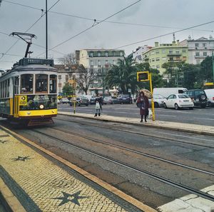 Cars on street in city against sky