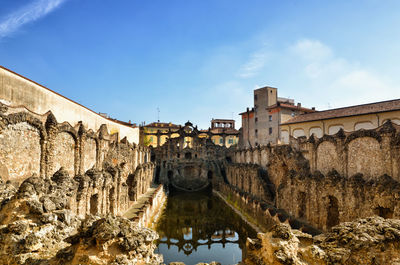 Arch bridge over canal against sky