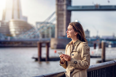 Young woman using mobile phone in city