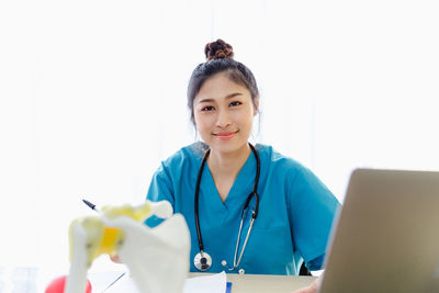 Portrait of a smiling young woman using smart phone