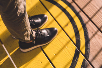 Low section of man standing on hardwood floor