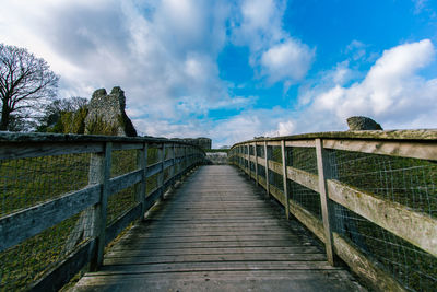 View of footbridge against cloudy sky