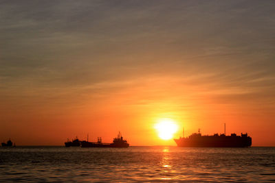 Silhouette ship sailing on sea against sky during sunset