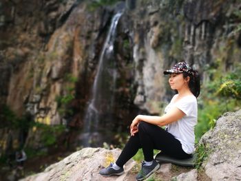 Woman sitting on rock in forest