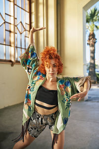 Young alternative redhead dancing in a green kimono