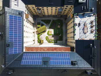 Aerial vie of courtyard surrounded by block of flats, solar panels on roof