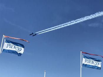 Low angle view of airplane flying against blue sky