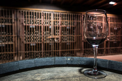 Close-up of wine glass on barrel