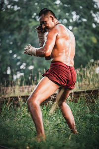 Full length of shirtless man on field