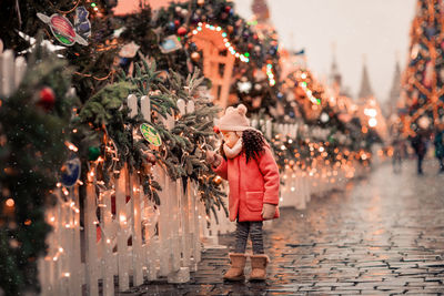 Person standing in illuminated christmas tree during winter