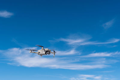 Low angle view of airplane flying against sky