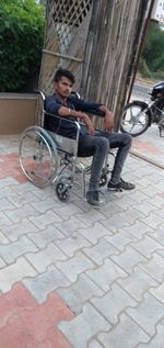 Full length of man sitting on footpath