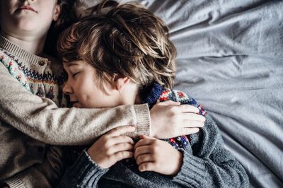 Directly above shot of children sleeping on bed at home