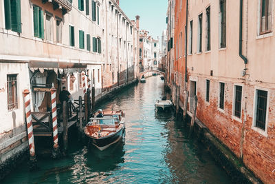 Boats in canal amidst buildings in city