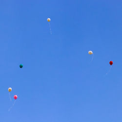 Low angle view of balloons against blue sky