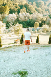 Rear view of woman walking by plants