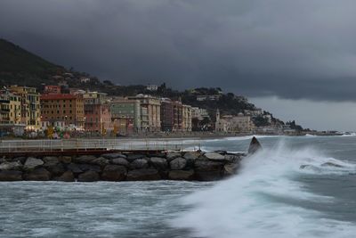 Scenic view of sea by buildings against sky