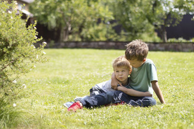 Portrait of boy sitting on field