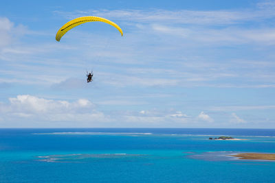 People paragliding over sea against sky