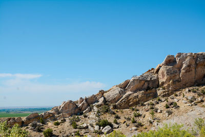 Scenic view of cliff against clear blue sky