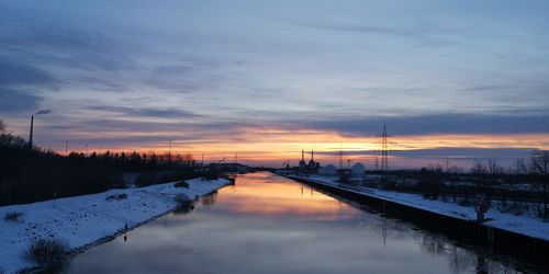 Scenic view of canal against sky during winter
