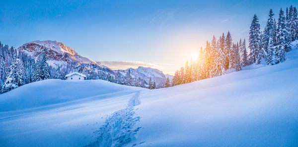 Scenic view of snow covered mountains against blue sky