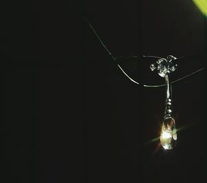 Close-up of lighting equipment hanging against black background