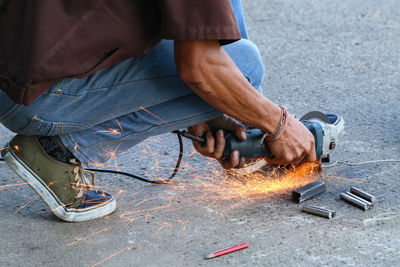 Low section of man cutting metal