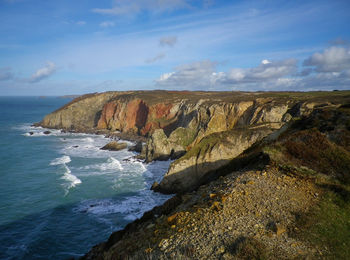 Scenic view of rocks on beach against sky