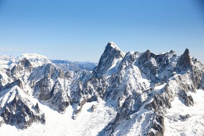 Scenic view of snowcapped mountains against clear blue sky