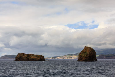 Rock formation in sea against sky