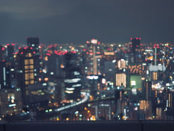 Illuminated cityscape against sky at night