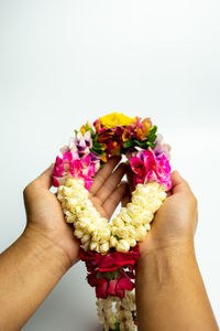 Midsection of person holding bouquet against white background