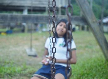 Close-up of girl on swing at playground