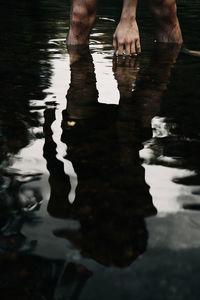 Low section of man standing in water