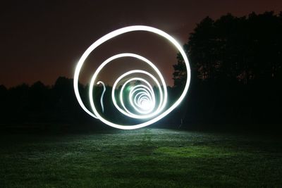 Light painting on field against sky at night