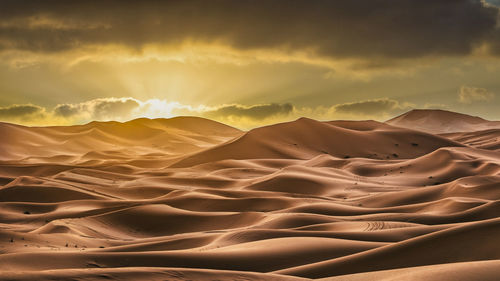 Scenic view of desert against sky during sunset