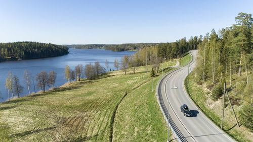 Panoramic view of road by lake against clear sky