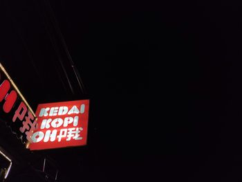 Low angle view of information sign against black background