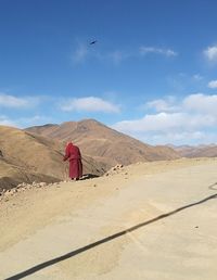 Rear view of man on desert against sky