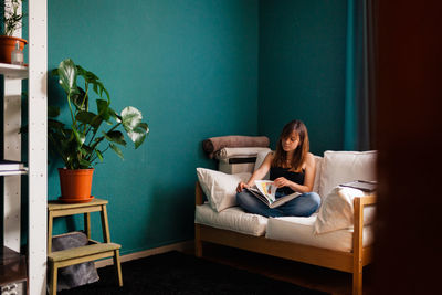 Young woman sitting on sofa at home