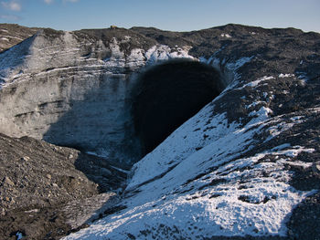 Cave and mountain against sky