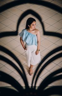 High angle portrait of woman standing on floor