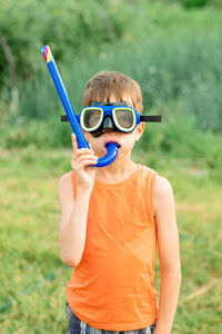 Portrait of a boy outdoors wearing swimming goggles and with a snorkel